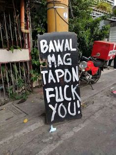 a sign that says bawal mag tapon fluck you on the side of the road