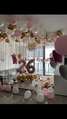 a room filled with balloons and decorations for a birthday party that looks like it has the number 26 on it