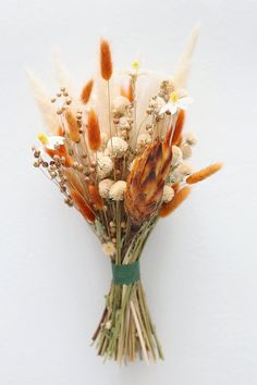 a bunch of dried flowers sitting on top of a white wall