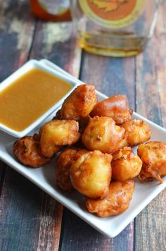 some food is on a white plate with dipping sauce