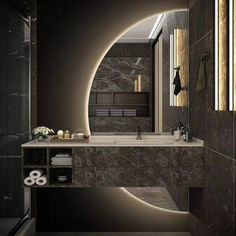 a bathroom with marble walls and flooring, along with a large mirror on the wall