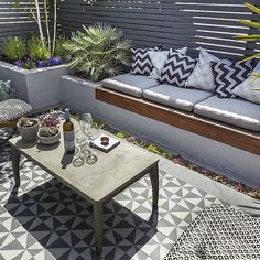 an outdoor living area with couches, tables and potted plants