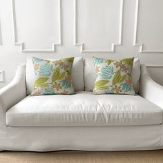 a white couch with two pillows on it