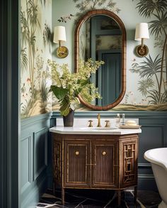 a bathroom with a sink, mirror and bathtub in the corner is decorated with tropical wallpaper