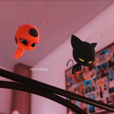 two little black cats hanging from the ceiling