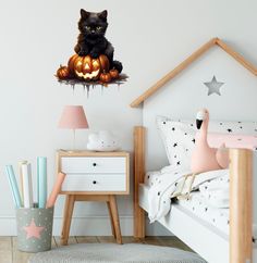 a black cat sitting on top of a bed next to a halloween pumpkin wall decal