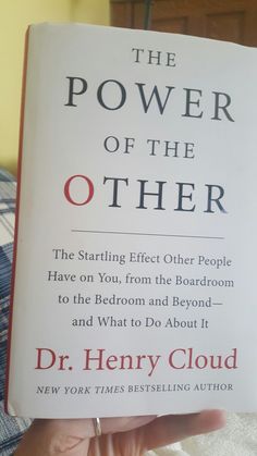 the power of the other book is being held up by someone's hand on a bed