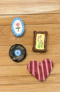 three decorated cookies sitting on top of a wooden table