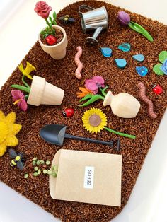 a table topped with lots of fake flowers and gardening items on top of brown grass