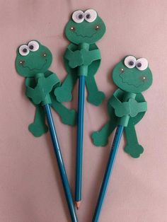 three pencils with paper cut out to look like frogs