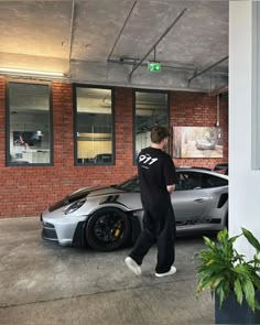 a man standing next to a silver sports car