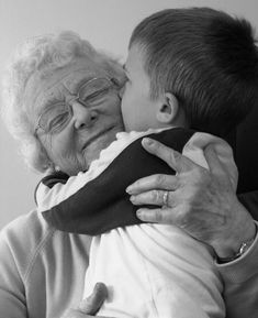 an older woman hugging a young boy with the words grandma's house on it