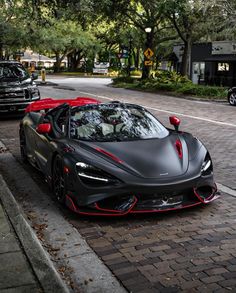 a black and red sports car is parked on the street