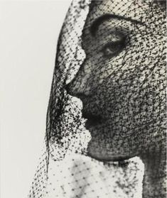 a black and white photo of a woman's face with veil on her head