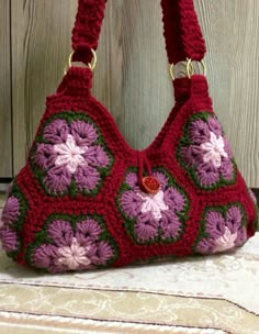 a crocheted purse sitting on top of a white table next to a wooden wall