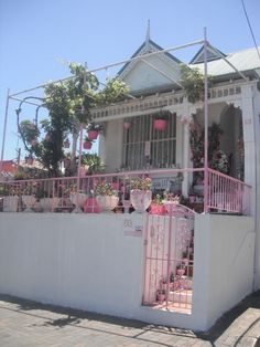 a white house with pink decorations on the front porch and balcony balconies above it