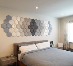 a bedroom with a bed, nightstands and wall art on the wall behind it