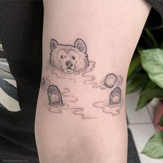 a person with a tattoo on their arm has a bear and mouse in the water