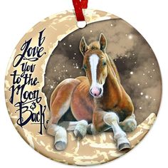 a ceramic ornament with a horse laying on it's side and the words look you to the moon back