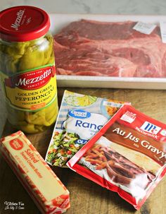 meat, cheese and other ingredients are sitting on a counter top next to a jar of mustard