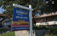 a real estate for sale sign in front of some houses