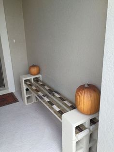 two pumpkins sitting on top of white benches