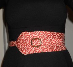 a woman wearing a red and white belt with an interlocked buckle on it