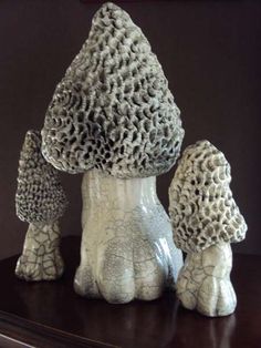 three ceramic mushrooms sitting on top of a table