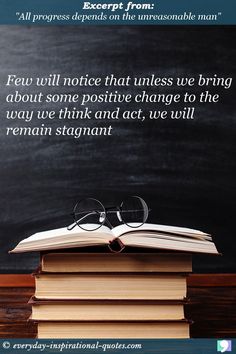 an open book sitting on top of a pile of books next to a blackboard