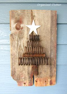 a christmas tree made out of old rusty springs on a wooden board with a white star