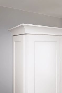 the corner of a white cabinet in a room