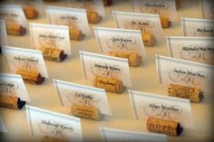 there are many wine corks with name tags attached to them on the table together