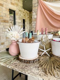 two white baskets filled with cosmetics sitting on top of a table next to a brick wall