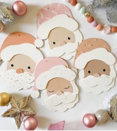 paper cutouts of santa claus and other christmas related items on a table with ornaments