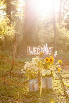 an image of a wedding sign in the grass with sunflowers and other flowers