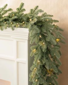 a christmas garland with lights hanging from it's side on a fireplace mantel