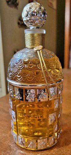 an ornate glass bottle sitting on top of a wooden table