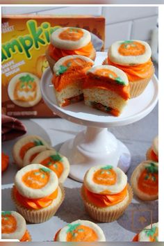 cupcakes with orange frosting and green sprinkles are on a cake plate