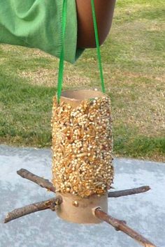 a person is holding a bird feeder made out of sticks