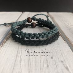 three bracelets with beads on them sitting on top of a wooden table