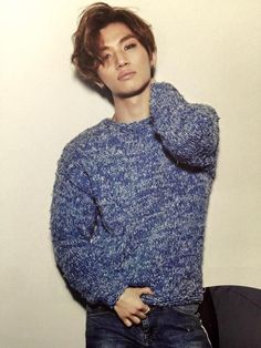 a young man wearing a blue sweater and jeans