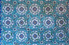 an intricately designed blue and green tile with flowers on the bottom, is shown