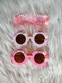 How adorable are these personalized sunnies!? Perfect for the summer sun! These custom sunglasses make the perfect gift or grab a pair for your little one! Each pair is handmade. Approx 5in wide across front of glasses Each pair will have personalized name you enter and decorated with flowers like shown in the pictures.  Please double check spelling. Custom Name Fun Sunglasses For Summer, Pink Personalized Adjustable Sunglasses, Custom Name Sunglasses For Summer Beach, Custom Name Sunglasses For Beach In Summer, Playful Personalized Pink Sunglasses, Custom Name Sunglasses As Summer Gift, Cute Personalized Adjustable Sunglasses, Cute Customizable Sunglasses For Gift, Custom Name Pink Sunglasses With Adjustable Fit