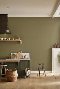 a kitchen with green walls and wooden floors