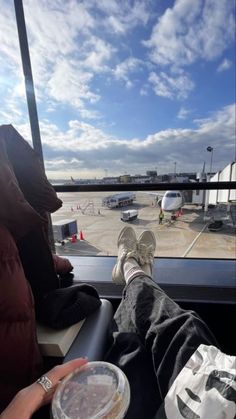 someone's feet on the seat of an airplane with their feet propped up in front of them