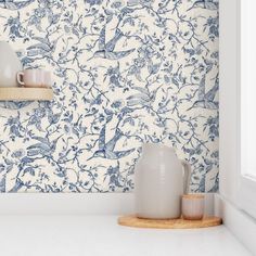 blue and white wallpaper in a kitchen with two vases on the counter top