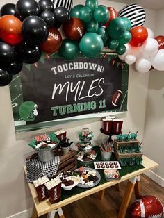 a football themed birthday party with balloons and desserts on a table in front of a chalkboard sign