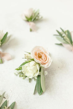 some white flowers and green leaves on a table