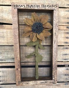 a wooden frame with a sunflower on it and the words teresa's primitive treasures