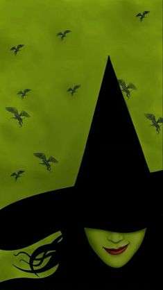 a woman wearing a black witches hat with birds flying around her and the background is green